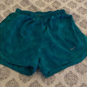 Nike shorts: Green triangle pattern.